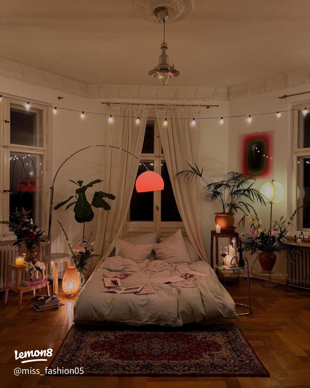 Cozy bedroom with string lights, plants, and a bed.